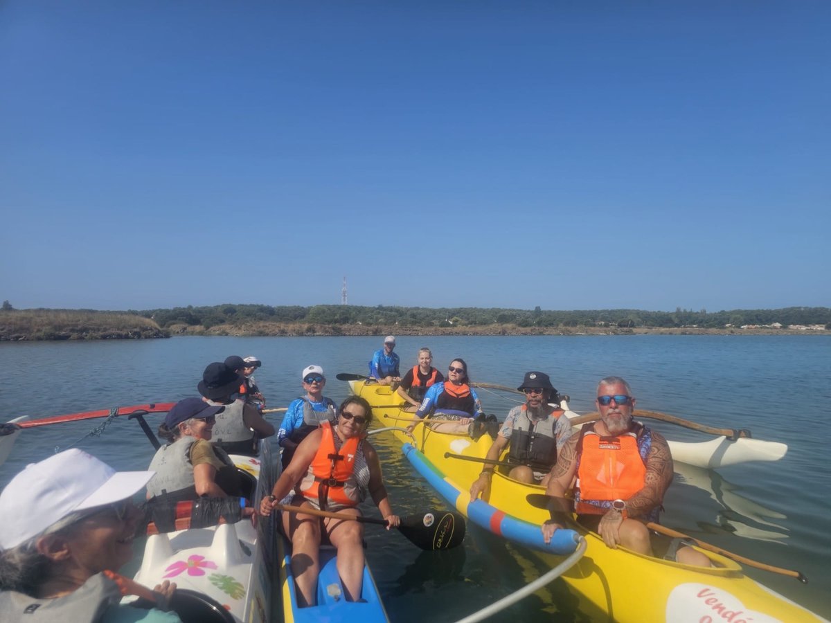 Un groupe de pagayeurs rassemblé en pirogues et kayaks sur l'eau calme du marais de la Ch'Noue